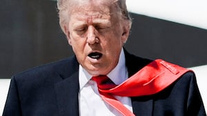 U.S. President Donald Trump's tie is blown by the wind as he walks to board Air Force One .