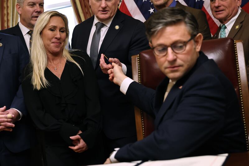 WASHINGTON, DC - JANUARY 23: Speaker of the House Mike Johnson (R-LA) hands the pen he used to sign the Laken Riley Act to Rep. Mike Collins (R-GA) during an enrollment ceremony with members of the Georgia delegation in Johnson's ceremonial office at the U.S. Capitol on January 23, 2025 in Washington, DC. Named after a young nursing student in Georgia who was murdered by a Venezuelan man, the Laken Riley Act requires the detainment of unauthorized immigrants accused of theft and violent crimes and it will be the first legislation that President Donald Trump will sign during his second term in office. (Photo by Chip Somodevilla/Getty Images)