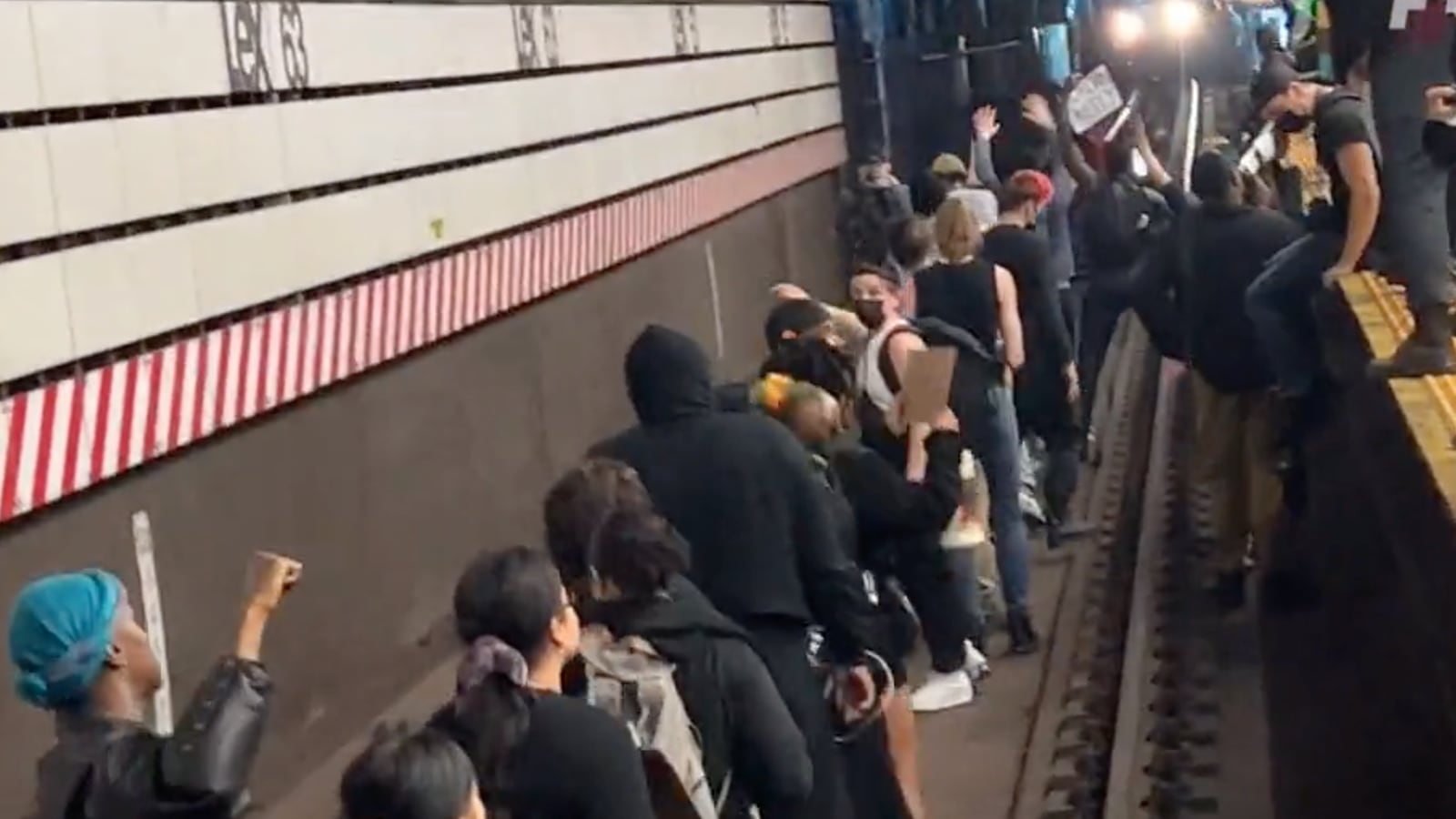 Protestors jump on subway track demanding the arrest of Daniel Penny.