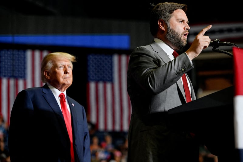 FILE PHOTO: Former U.S. president Donald Trump listens as JD Vance speaks during a rally in Youngstown, Ohio, U.S., September 17, 2022.  REUTERS/Gaelen Morse/File Photo
