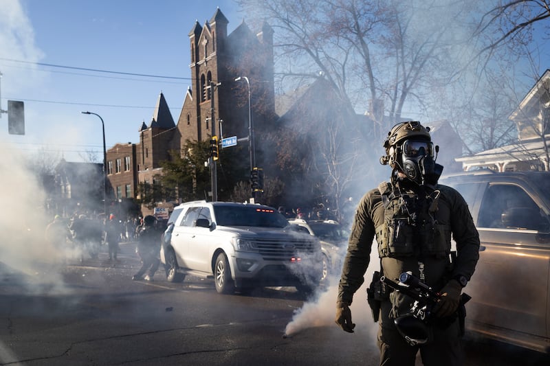 MINNEAPOLIS, MINNESOTA - JANUARY 13: Tear gas tossed by federal immigration agents fills the air as agents clash with residents while trying to retreat following a house raid on January 13, 2026 in Minneapolis, Minnesota. The Trump administration has sent an estimated 2,000 federal agents into the area, with more on the way, as they make a push to arrest undocumented immigrants in the region. (Photo by Scott Olson/Getty Images)