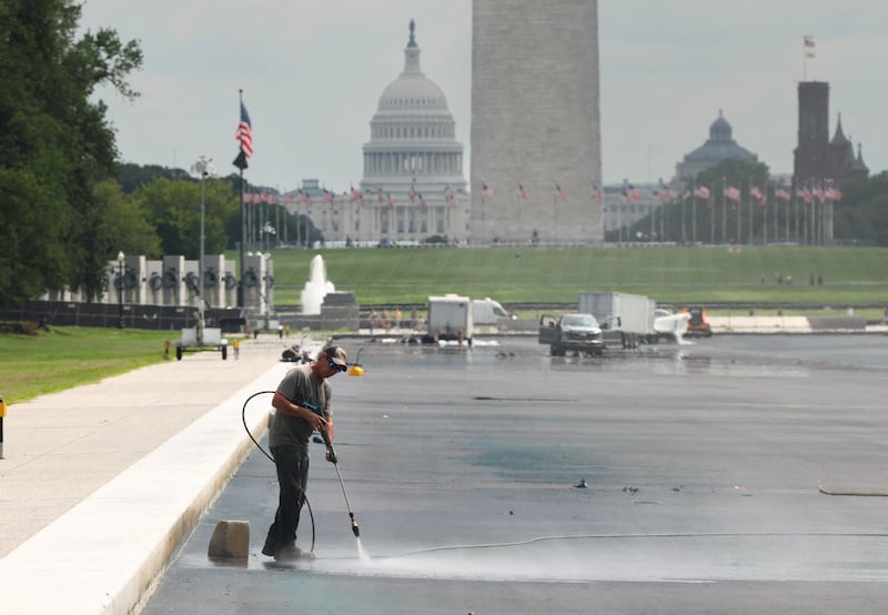 A worker power washes a section of the Lincoln Memorial Reflecting Pool as work continues to correct the botched repair project in Washington, D.C., U.S., August 18, 2026. REUTERS/Kevin Lamarque