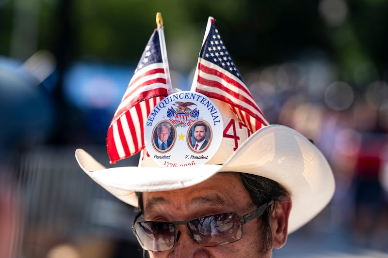 An attendee wears a hat with buttons featuring U.S. President Donald Trump and U.S. Vice President JD Vance