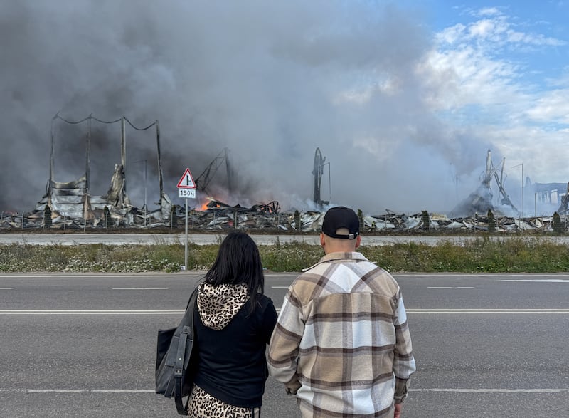 People watch the burning Wildberries warehouses following a Ukrainian drone attack, according to the regional governor, in the course of the Russia-Ukraine conflict, in Koledino, Moscow Region, Russia August 16, 2026.  Picture taken with mobile phone. REUTERS/Stringer