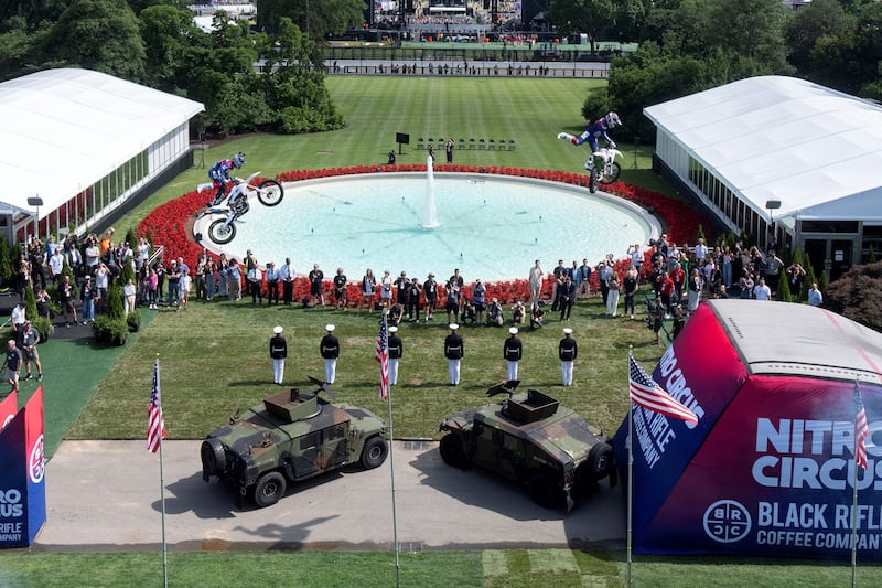 Motor sports athletes and stunt performers do a motorcycle jump ahead of the UFC Freedom 250 fights.