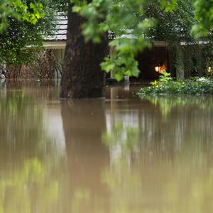 A home in River Plantation is seen with its lights on in flood water.