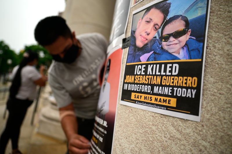 NEW HAVEN, CONNECTICUT, JULY 15, Organizers with immigrant rights group Unidad Latina en Acción tape flyers depicting people who have been killed by ICE to the pillars of the federal courthouse in New Haven, Conn. on July 15, 2026 before a protest against the recent ICE Killing of Joan Sebastián Durán Guerrero in Biddeford, Maine. "It's time to say we cannot be silenced anymore," said John Lugo, one of the protest's organizers.