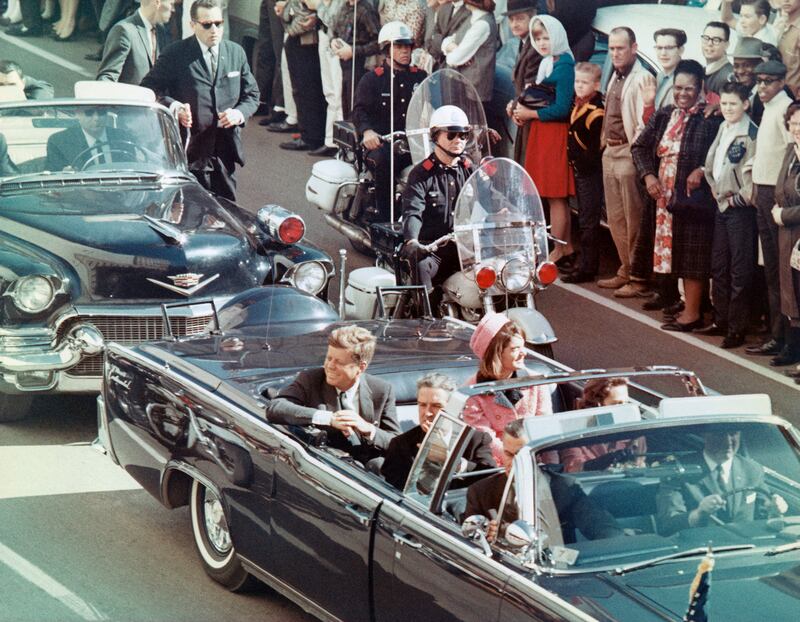 President John F. Kennedy, First Lady Jacqueline Kennedy, Texas Governor John Connally, smile at the crowds lining their motorcade route in Dallas.