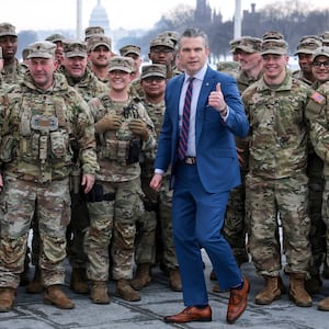 U.S. Defense Secretary Pete Hegseth poses with U.S. Army National Guard soldiers.