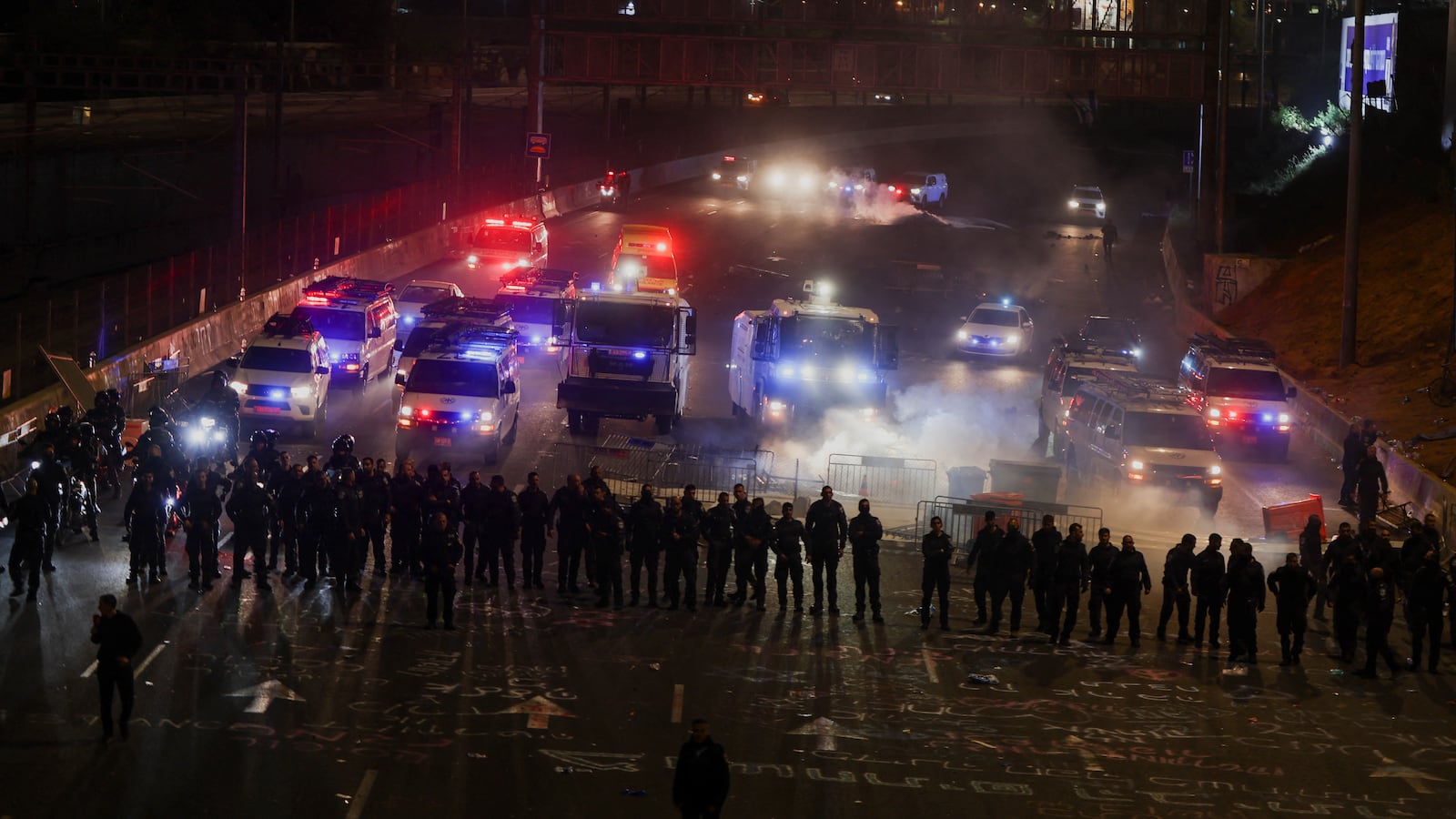Members of security forces stand guard as people attend a demonstration after Israeli Prime Minister Benjamin Netanyahu dismissed the defense minister.