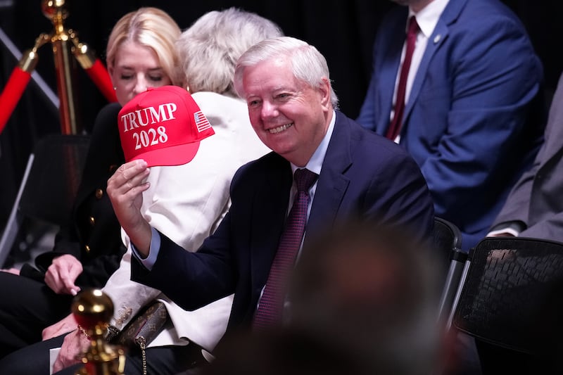 U.S. Sen. Lindsey Graham (R-SC) holds up a hat that reads "Trump 2028" during an event at the Kennedy Center.