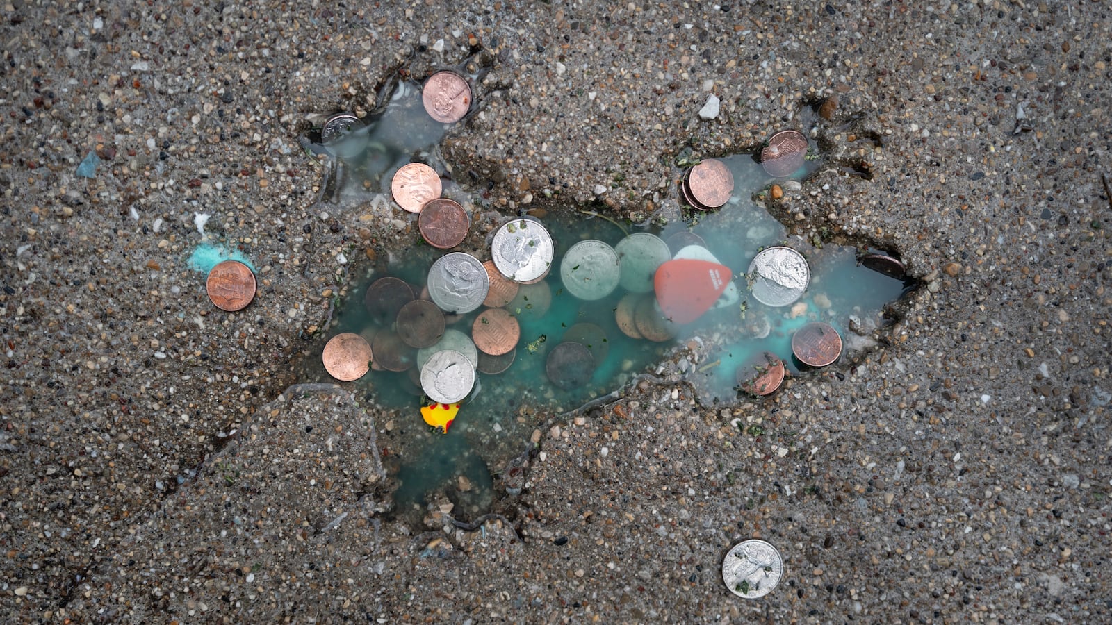 CHICAGO, ILLINOIS - JANUARY 24: Coins are left behind by visitors at an impression in a sidewalk in the Roscoe Village neighborhood known as the Chicago Rat Hole on January 24, 2024 in Chicago, Illinois. The decades-old impression in the the shape of a rat (or squirrel) began attracting a regular stream of visitors after a post on X garnered more than 5 million views. (Photo by Scott Olson/Getty Images)