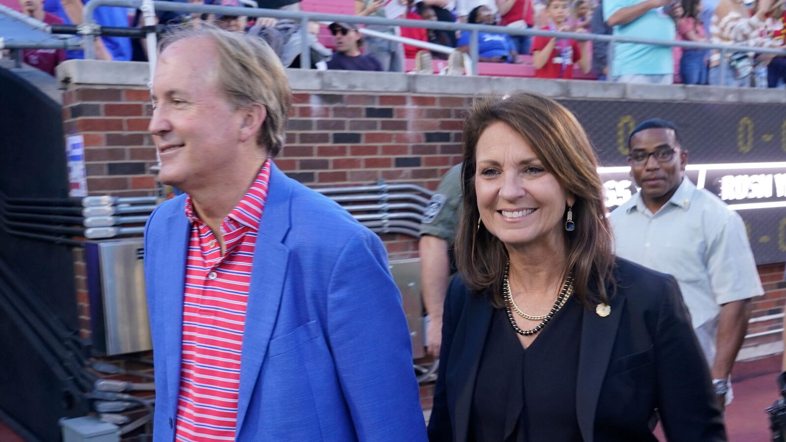 Texas Attorney General Ken Paxton, left, walks with his wife and Texas State Sen. Angela Paxton on the sideline before an NCAA college football game between Navy and SMU in Dallas, Friday, Oct. 14, 2022.