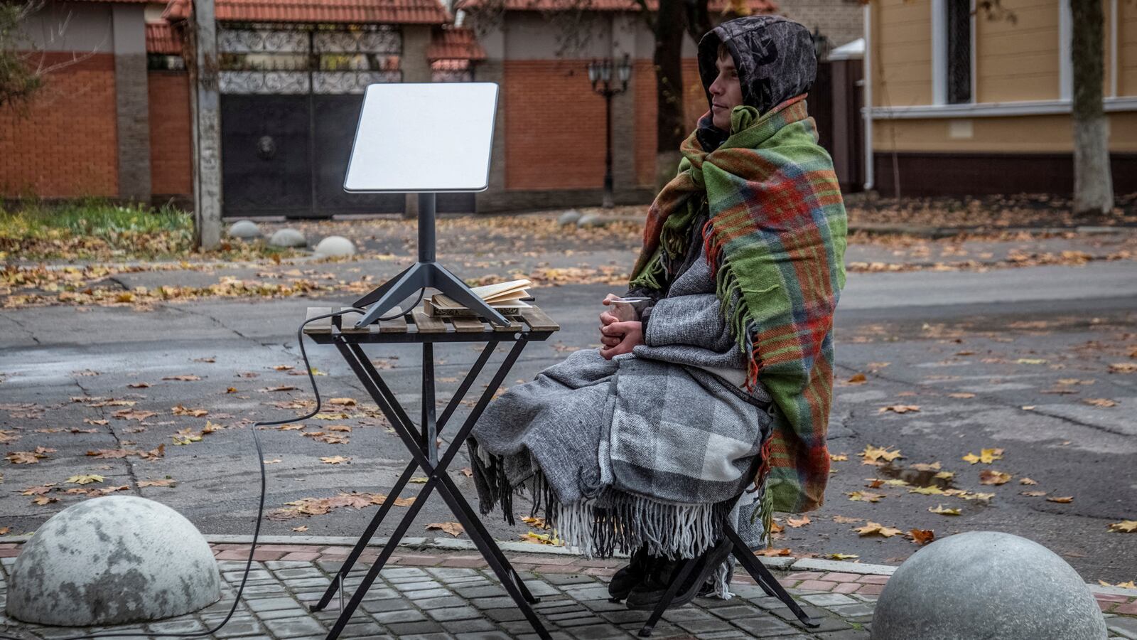 "A volunteer seats near a Starlink terminal constructed for local residents at a street, as Russia's attack on Ukraine continues, in Kherson, Ukraine.