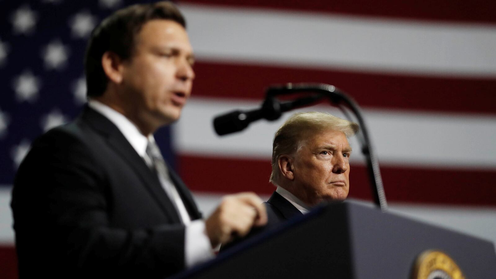 Donald Trump listens as Ron DeSantis speaks during a Make America Great Again Rally at the Florida State Fairgrounds in Tampa, Florida, U.S., July 31, 2018.
