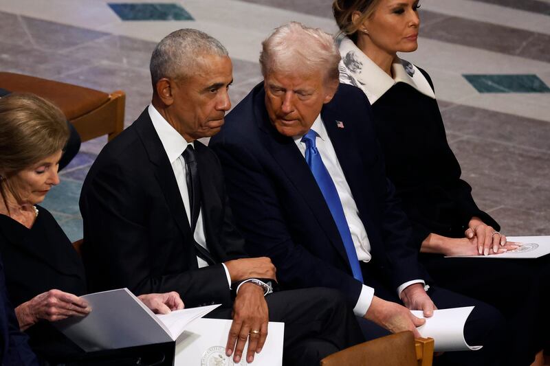Barack Obama and Donald Trump speak as former first ladies Laura Bush (L) and Melania Trump (R) look on during the state funeral for former U.S. President Jimmy Carter at Washington National Cathedral on January 09, 2025 in Washington, DC.