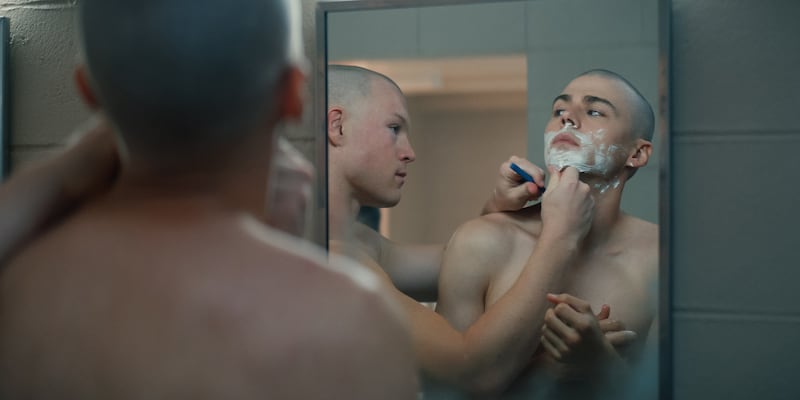 Still from Boots of two men shaving in the mirror.