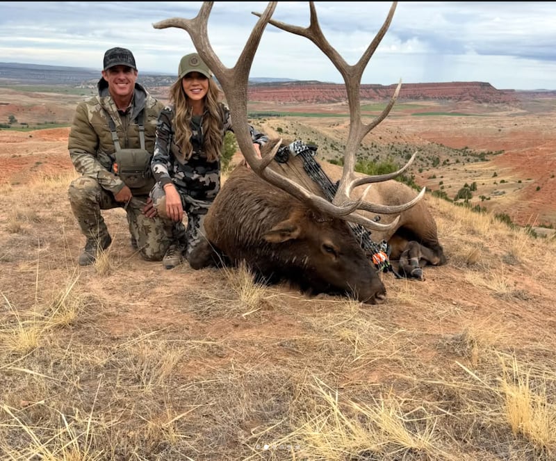 Kristi Noem with a hunting buddy and the dead Elk