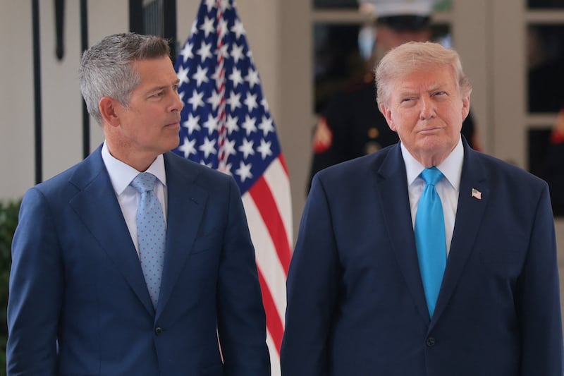 U.S. Secretary of Transportation Sean Duffy looks at U.S. President Donald Trump.