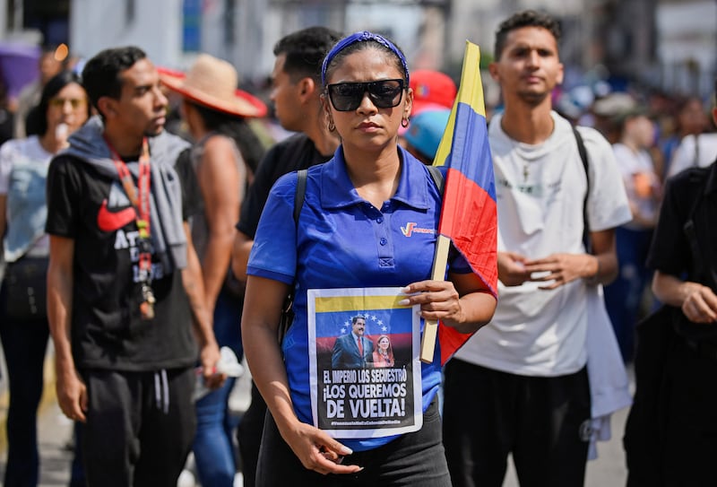 A demonstrator holds a sign reading "The empire kidnapped them, we want them back" during a march outside the National Assembly on the day Vice President Delcy Rodriguez was formally sworn in as Venezuela's interim president, as U.S.-deposed President Nicolas Maduro appeared in a New York court after the Trump administration removed him from power, in Caracas, Venezuela, on January 5, 2026.