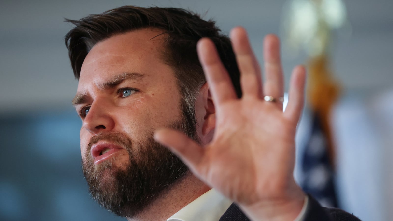 J.D. Vance holds up a hand while speaking at an event.