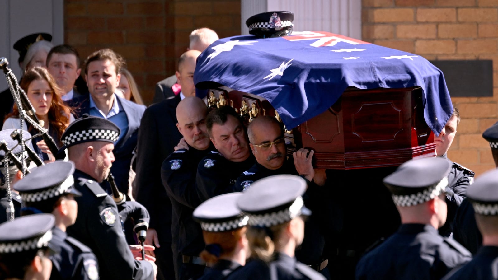 The coffin of police officer Senior Constable Vadim de Waart-Hottart is carried from the Victoria Police Academy chapel following his funeral service in Melbourne on September 5, 2025. Around a thousand people have gathered for a funeral of de Waart-Hottart, one of two Victoria Police officers killed in a shooting at Porepunkah in Victoria's north-east last week. Suspected gunman Dezi Freeman fled into dense bushland on foot, sparking an enormous manhunt involving hundreds of police officers that is now in its eleventh day.