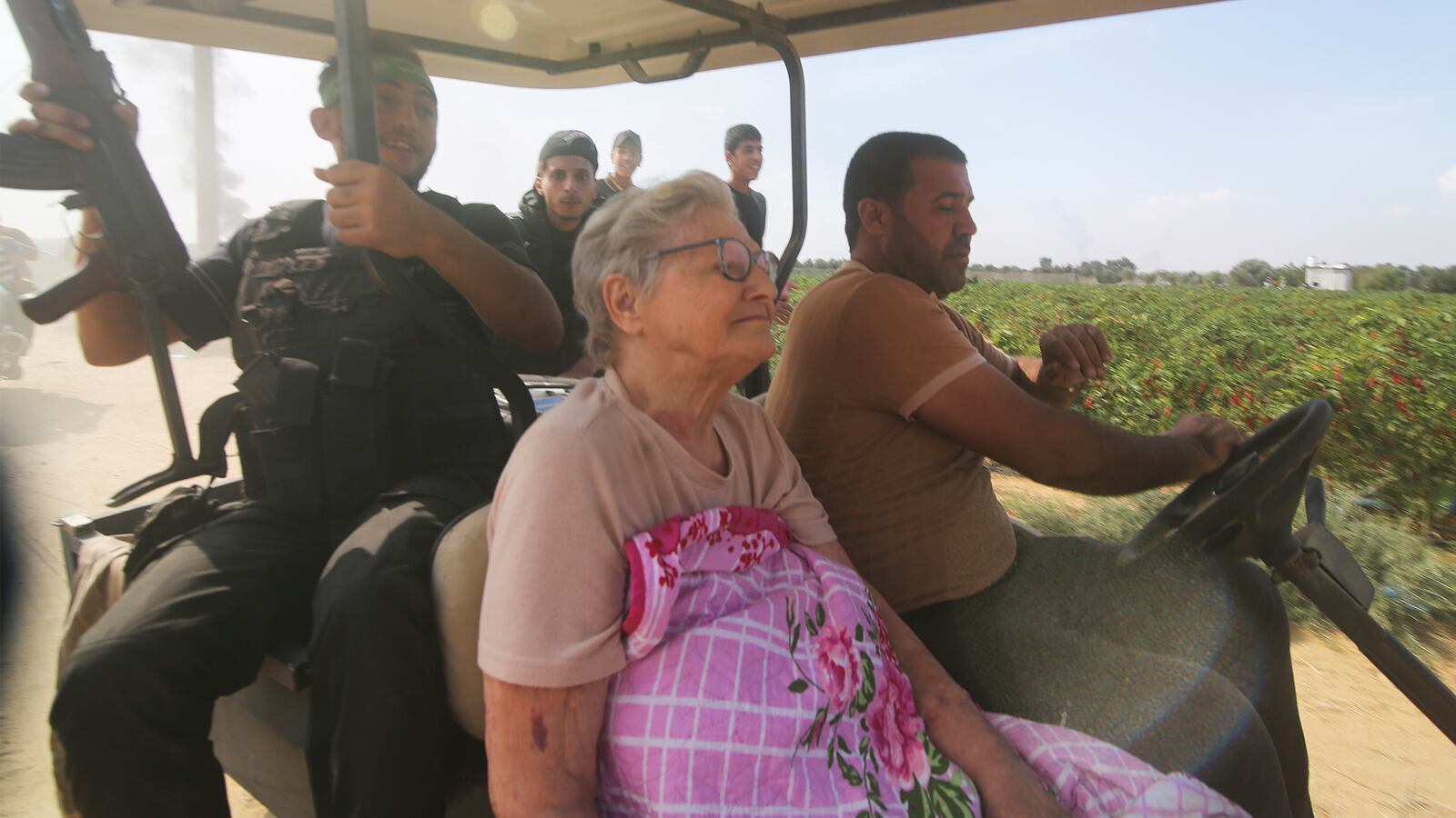 Palestinians transport a captured Israeli Yaffa Adar, center, from Kibbutz Kfar Azza into the Gaza Strip on Oct. 7, 2023.