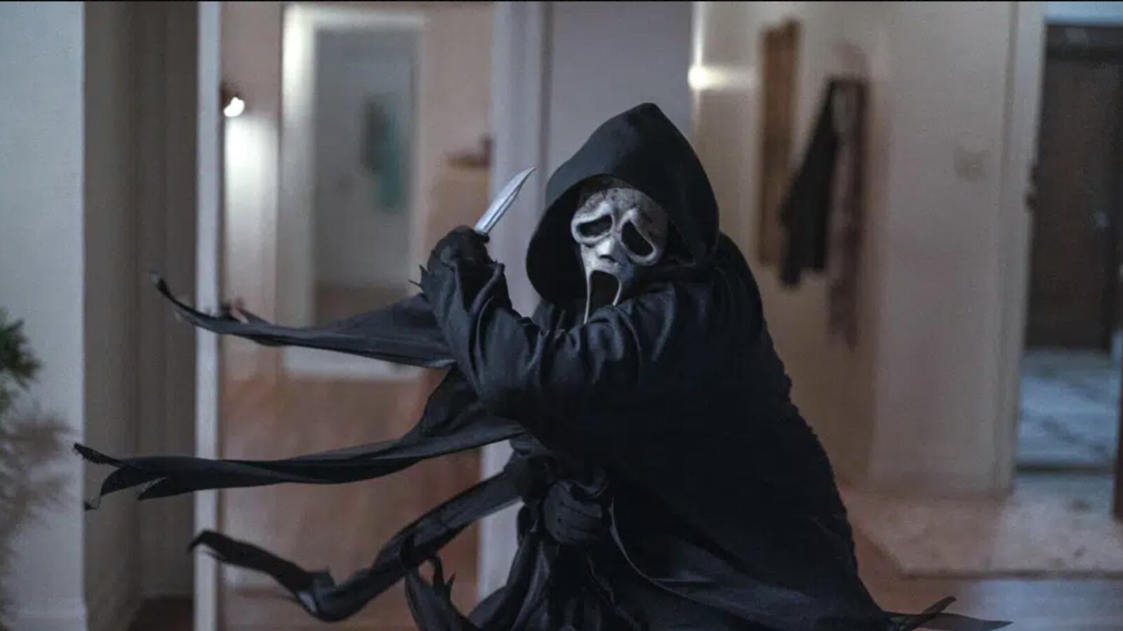 Ghostface swipes his knife as he attacks in an apartment