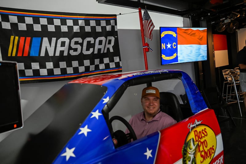 The North Carolina flag is displayed on a screen as visitors pose for photographs in the North Carolina state exhibit during The Great American State Fair on the National Mall in Washington D.C., U.S., June 27, 2026.