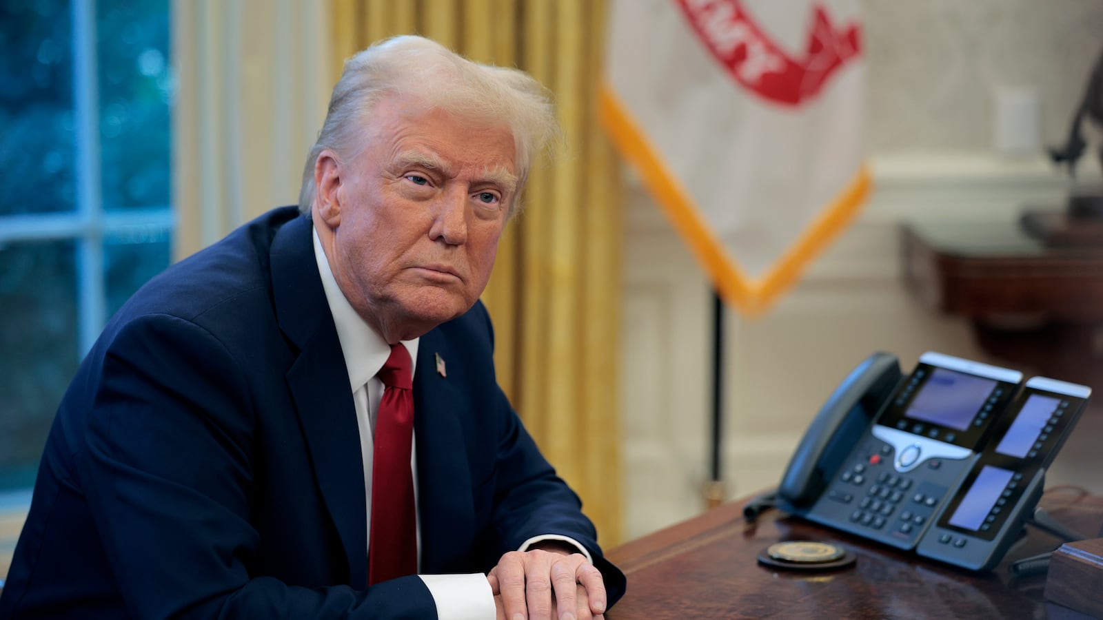 President Donald Trump sits at the Resolute Desk in the Oval Office on Jan. 30.