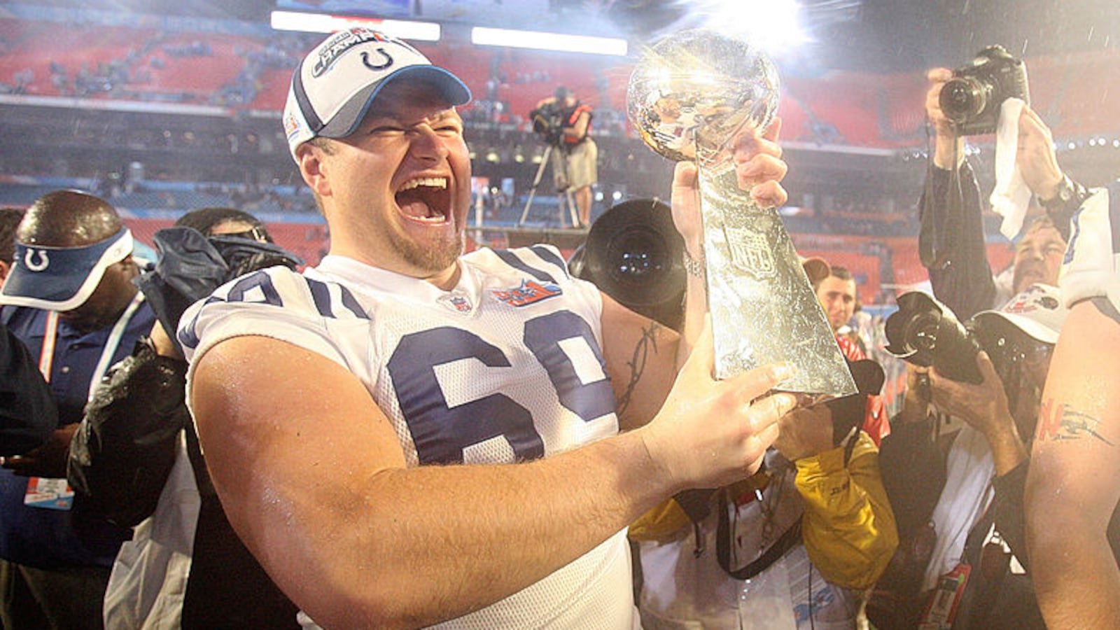 Matt Ulrich smiles big as he holds the Lombardi Trophy on the field after winning the Super Bowl.