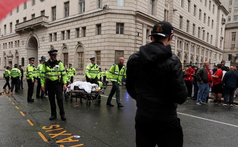 A person is taken away on a stretcher after a vehicle rammed into Liverpool supporters on Monday.