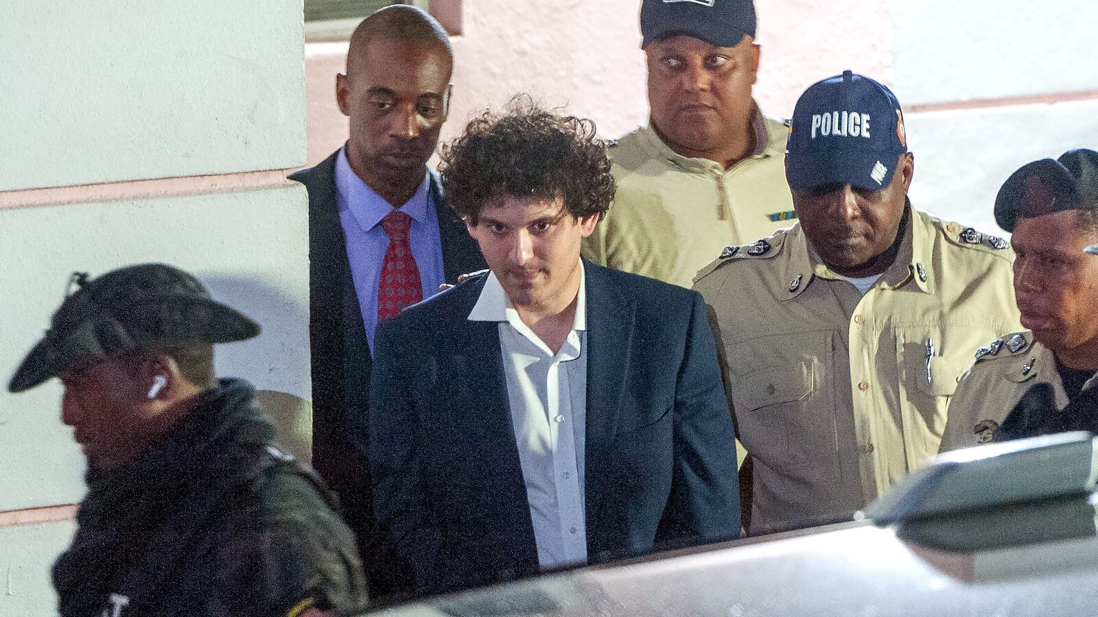 FTX founder Sam Bankman-Fried is led away handcuffed by officers of the Royal Bahamas Police Force in Nassau.