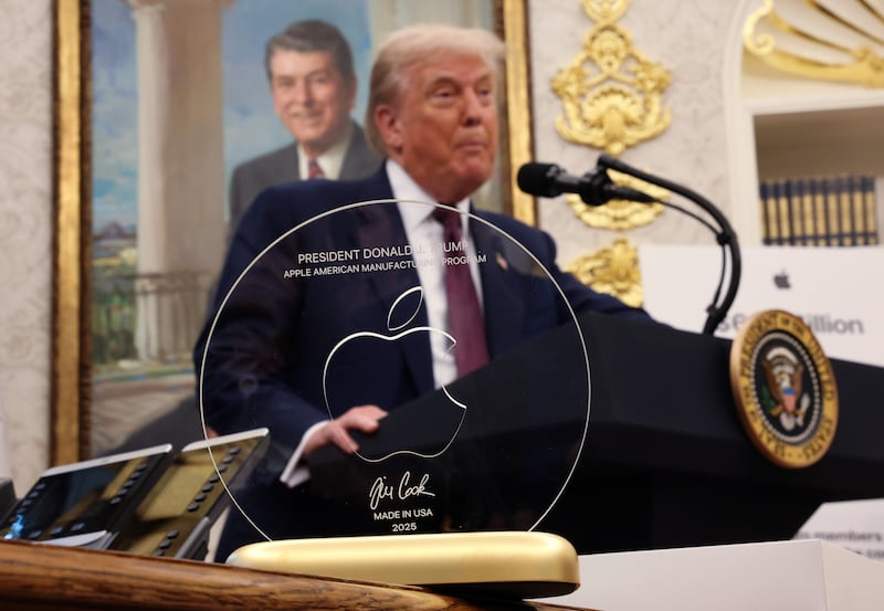 U.S. President Donald Trump speaks behind an engraved glass disc gifted to him by Apple CEO Tim Cook during an event in the Oval Office of the White House on August 6, 2025 in Washington, DC.