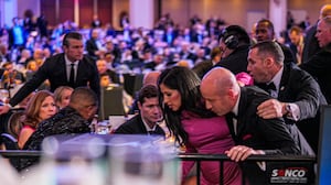 Secretary of War Pete Hegseth (L) stands as White House Deputy Chief of Staff for Policy Stephen Miller and his wife Katie Miller (C) are taken out of the ballroom by security agents during a shooting incident at the annual White House Correspondents Association Dinner at the Washington Hilton on April 25, 2026 in Washington, DC.