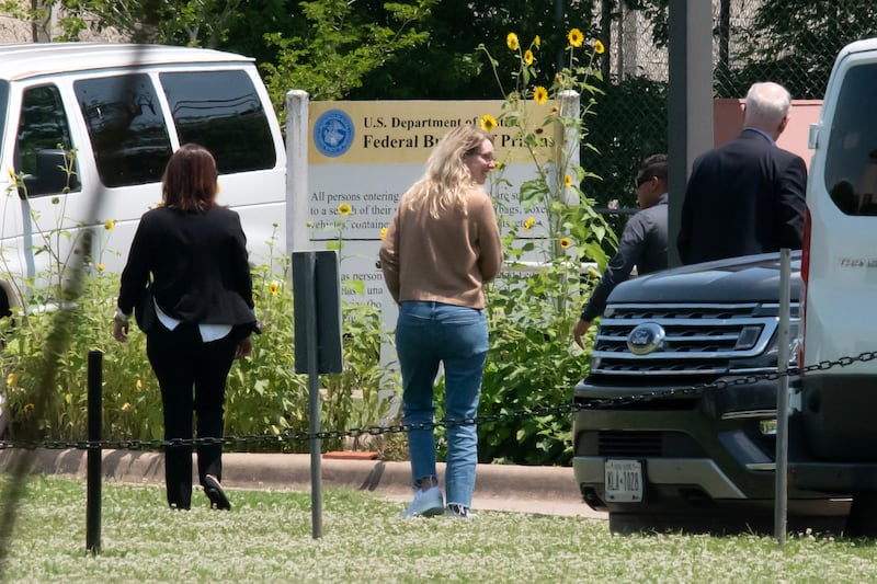 Theranos' founder Elizabeth Holmes (C) arrives, flanked by prision officials, at the Federal Prison Camp in Bryan, Texas, on May 30, 2023. Holmes was ordered to begin serving prison time at the camp on May 30 after a court denied her latest request to remain free while appealing her fraud conviction. Holmes was sentenced to just over 11 years in prison for defrauding investors with her Silicon Valley start-up Theranos.