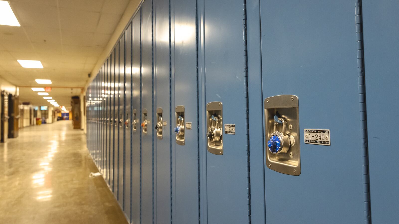A picture shows an empty corridor and student lockers of a school complex.