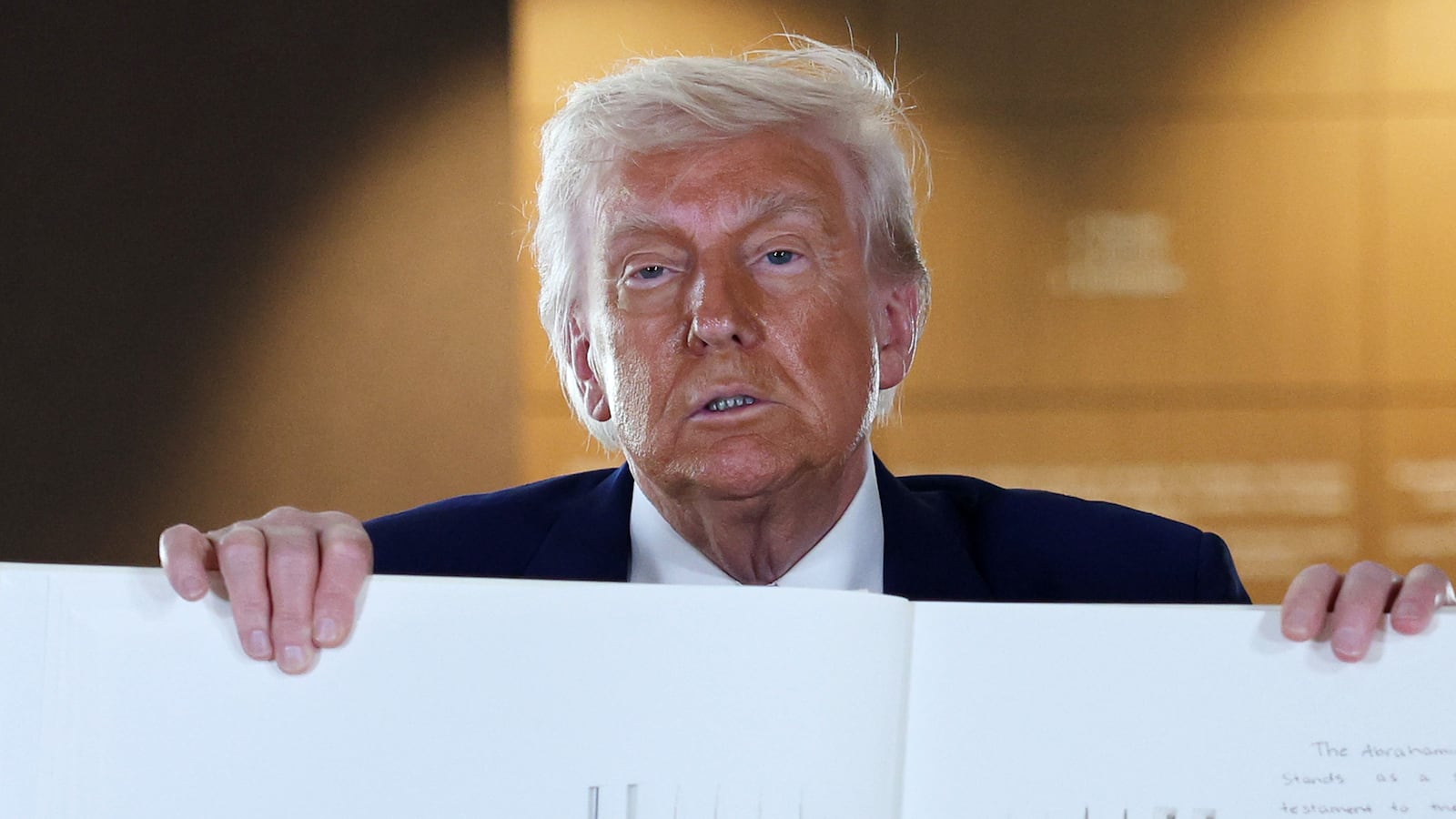 U.S. President Donald J. Trump signs a guest book as he tours the Abrahamic Family House during a cultural visit on May 16, 2025, in Abu Dhabi, United Arab Emirates.