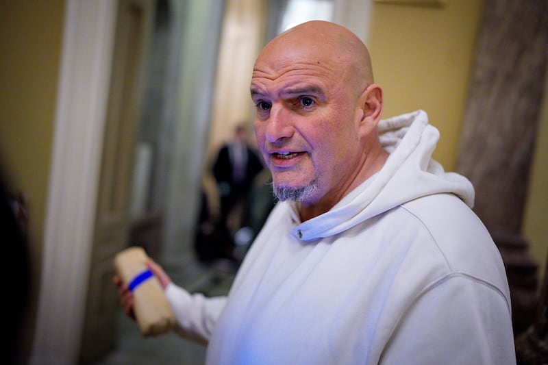 U.S. Sen. John Fetterman (D-PA) (L), one of eight Democrats to say he will vote with Republicans to open the government, speaks to reporters outside the Senate Chamber during votes on November 10, 2025 on Capitol Hill in Washington, DC.