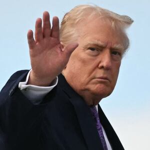 US President Donald Trump waves while boarding Air Force One at Palm Beach International Airport on November 30, 2025, on his way back to Washington, DC. President Trump and First Lady Melania Trump spent the Thanksgiving holiday at his Mar-a-Lago residence. (Photo by Jim WATSON / AFP via Getty Images)