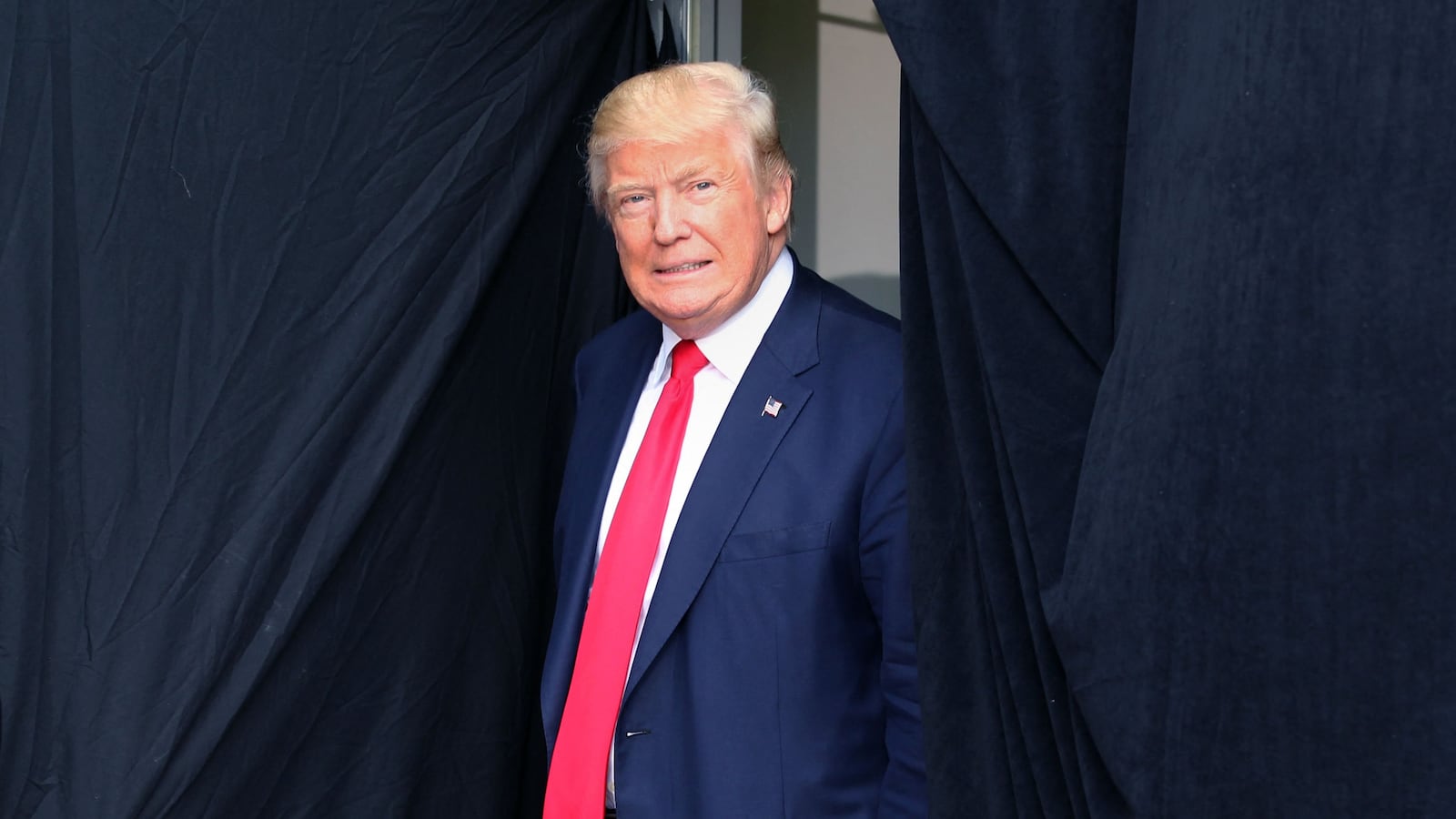 TOPSHOT - Republican presidential candidate Donald Trump comes out from behind a curtain to take the stage at an event on October 15, 2016 in Portsmouth, New Hampshire. (Photo by Mary Schwalm / AFP) (Photo by MARY SCHWALM/AFP via Getty Images)