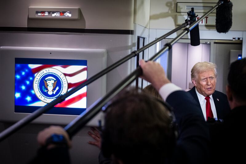 President Donald Trump speaks to the media aboard Air Force One