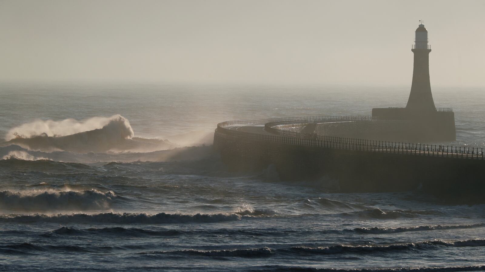 Waves crash over near the lighthouse on Roker Beach, in Sunderland, Britain.