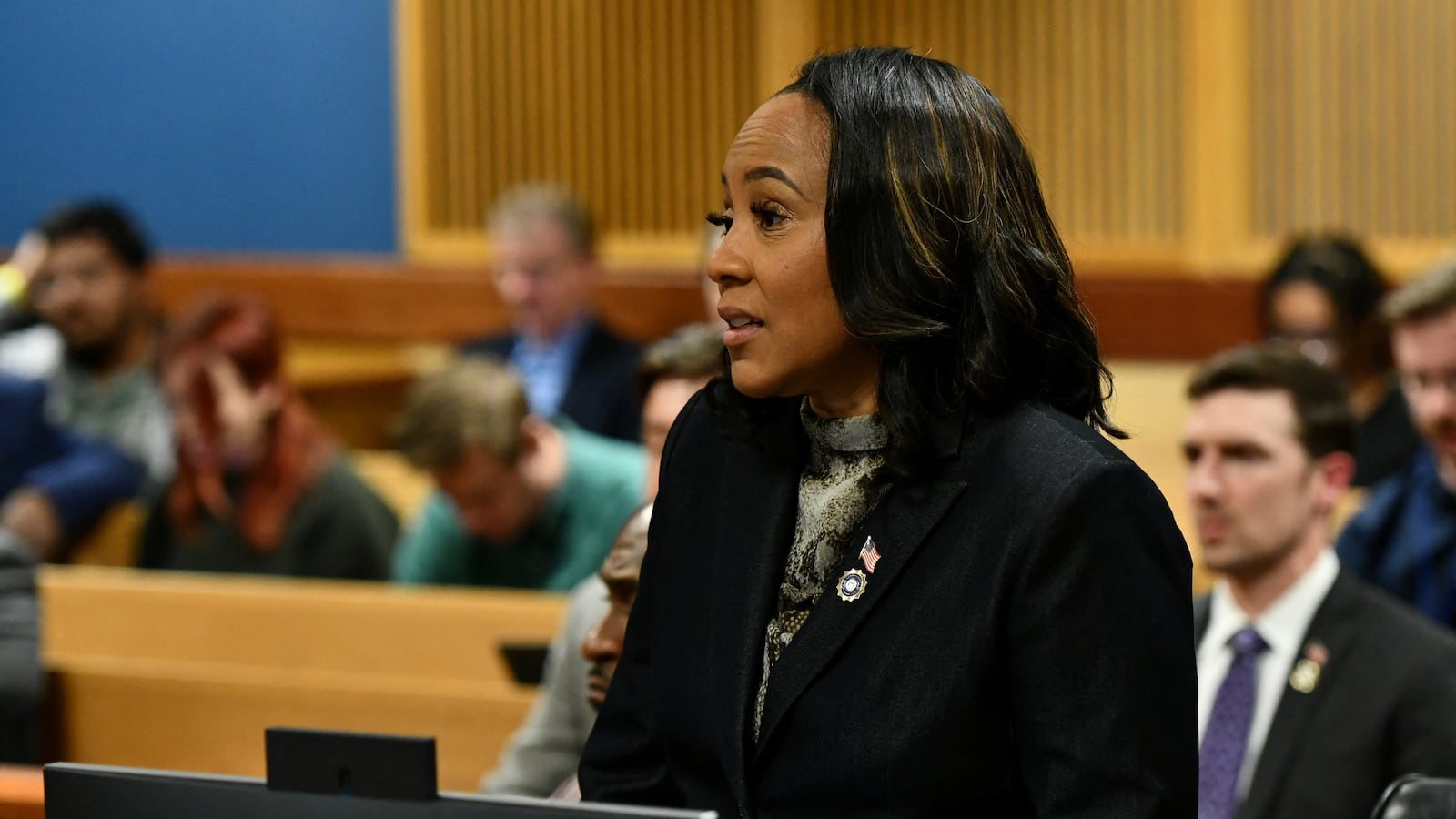 Fani Willis in suit blazer speaking at a hearing in Fulton County Courthouse in Atlanta.