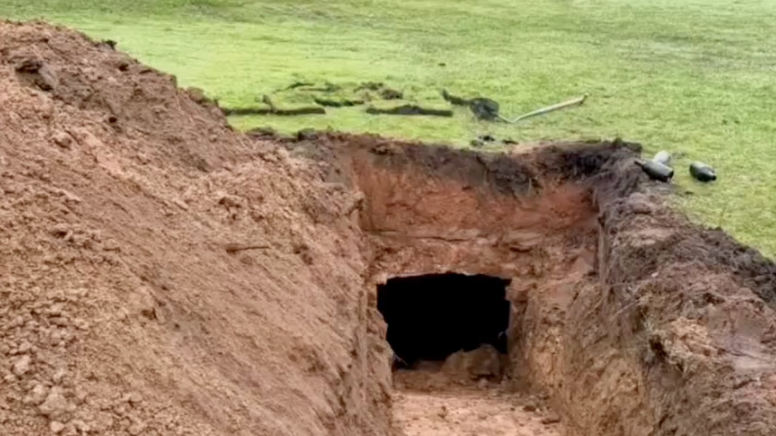 Entrance of the cellar dug out with wine bottles to the side.