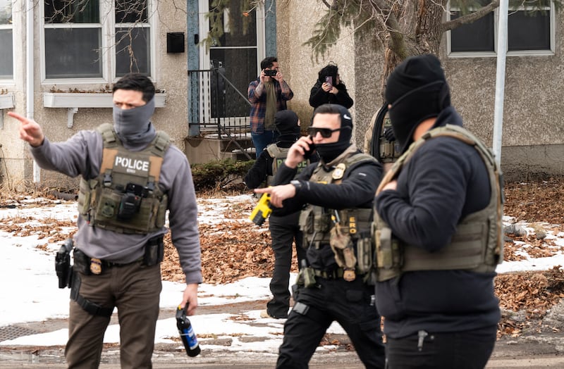 Observers film ICE agents as they hold a perimeter after one of their vehicles got a flat tire on Penn Avenue on February 5, 2026 in Minneapolis, Minnesota.