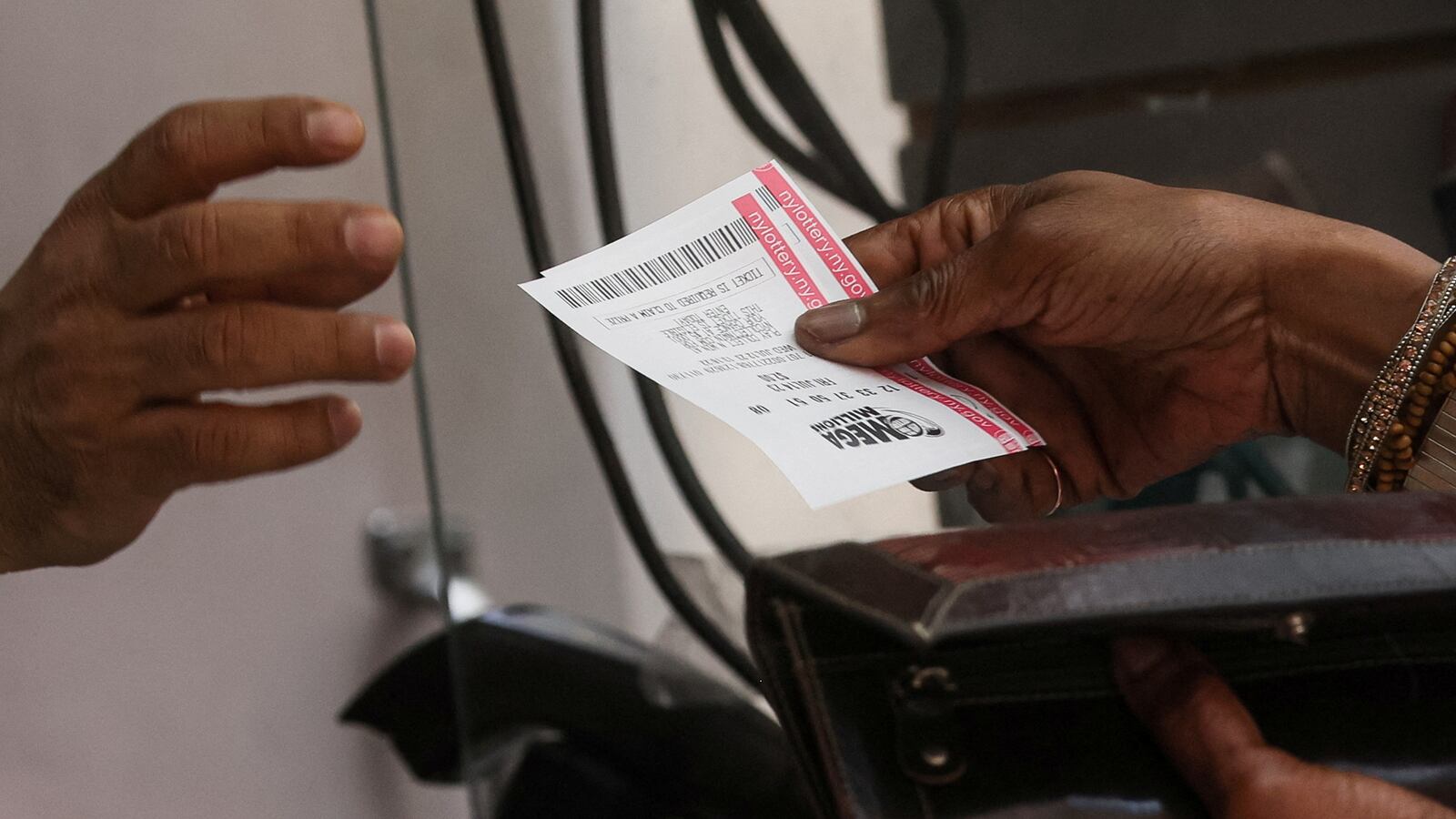 A customer purchases a Mega Millions and Powerball tickets in New York City.