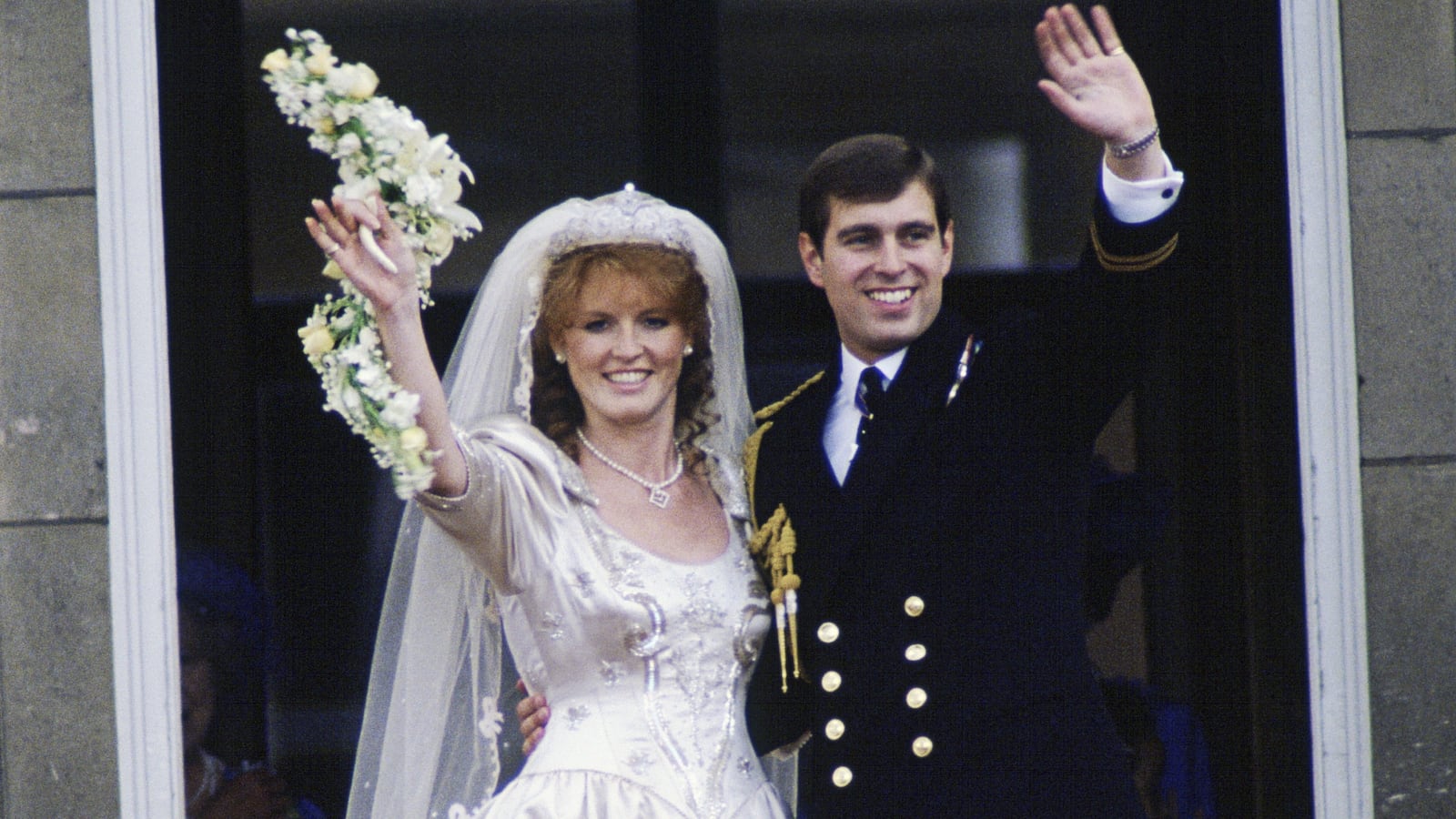 The Duke and Duchess of York, Sarah Ferguson and Prince Andrew, waving to the crowds from the balcony at Buckingham Palace on their wedding day.