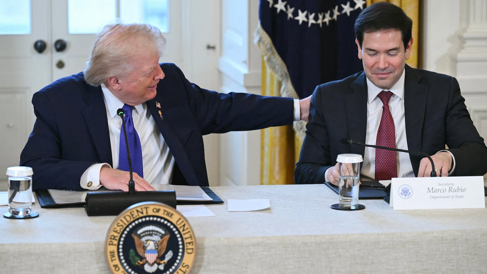 US President Donald Trump speaks with US Secretary of State Marco Rubio (R) during a meeting with US oil companies executives in the East Room of the White House in Washington, DC on January 9, 2026. President Trump is aiming to convince oil executives to support his plans in Venezuela, a country whose energy resources he says he expects to control for years to come. US forces seized Venezuelan president Nicolas Maduro in a sweeping military operation on January 3, with Trump making no secret that control of Venezuela's oil was at the heart of his actions. (Photo by SAUL LOEB / AFP via Getty Images)
