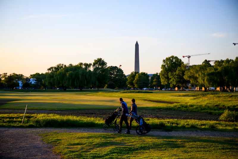 WASHINGTON, DC - MAY 3: People play golf as the Washington Monument is visible in the background at the East Potomac Golf Links on May 3, 2026 in Washington, DC. Reports were circulating that the administration planned to take over operations of the popular municipal golf course as soon as Sunday evening, even as officials have offered few details to the public or the course's current operator.(Photo by Pete Kiehart for The Washington Post via Getty Images)